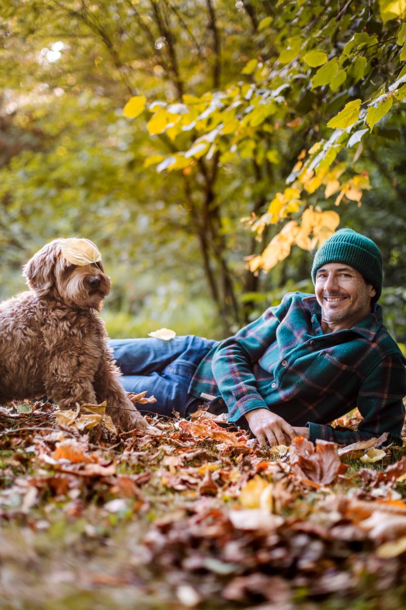 Dieter Coppens ligt met hond tussen de bladeren