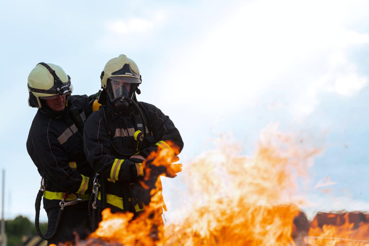 twee brandweerlui blussen een klein vuur