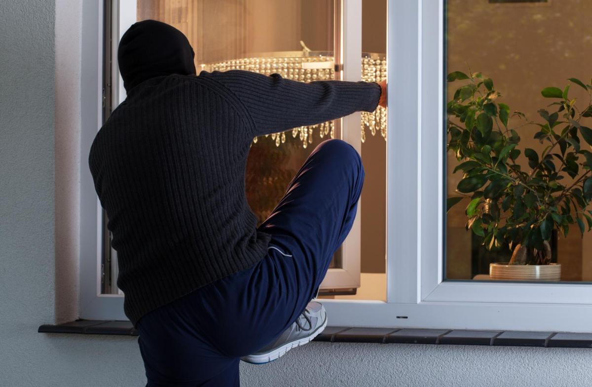 dief kruipt door open raam