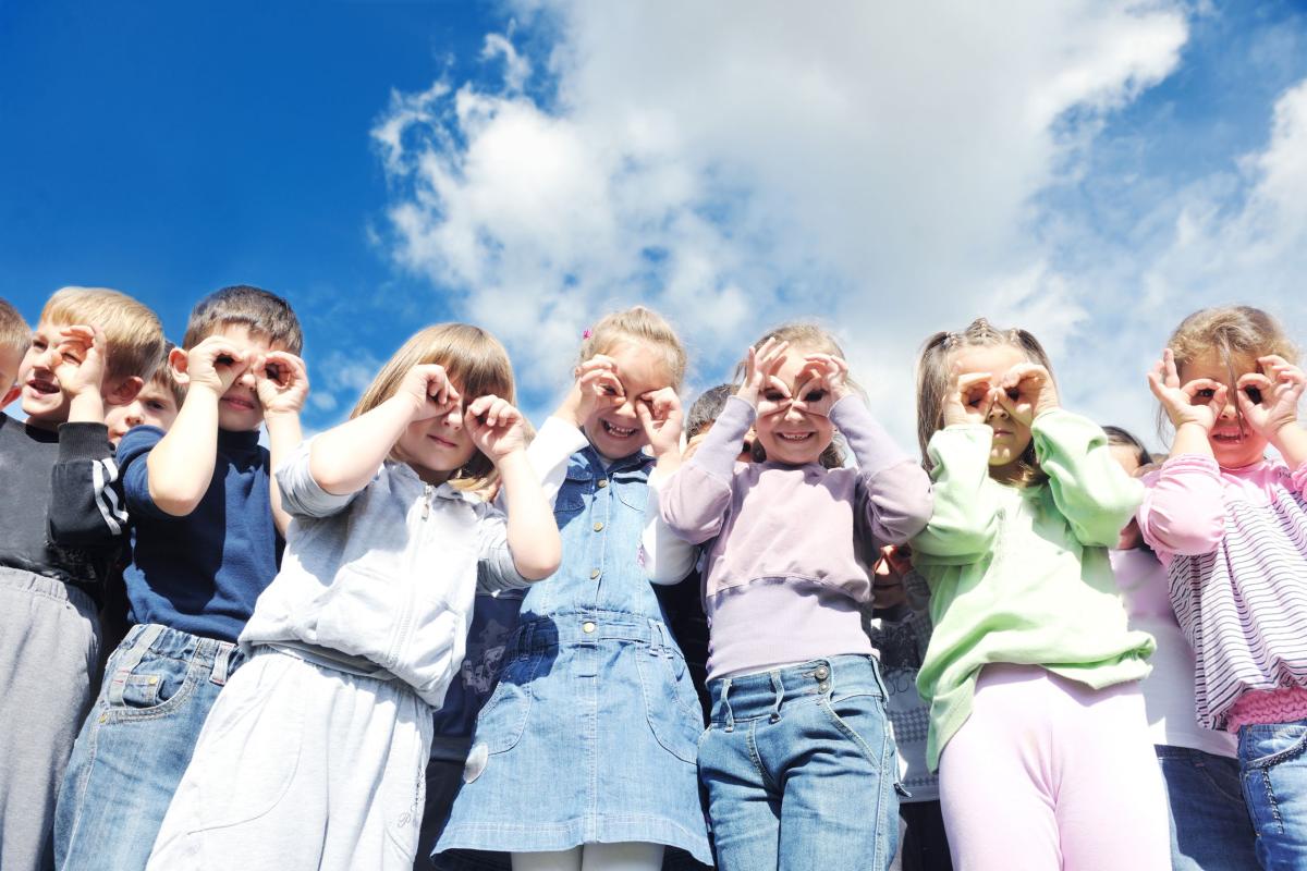 een groep kinderen maken met hun hand een verrekijker voor hun ogen