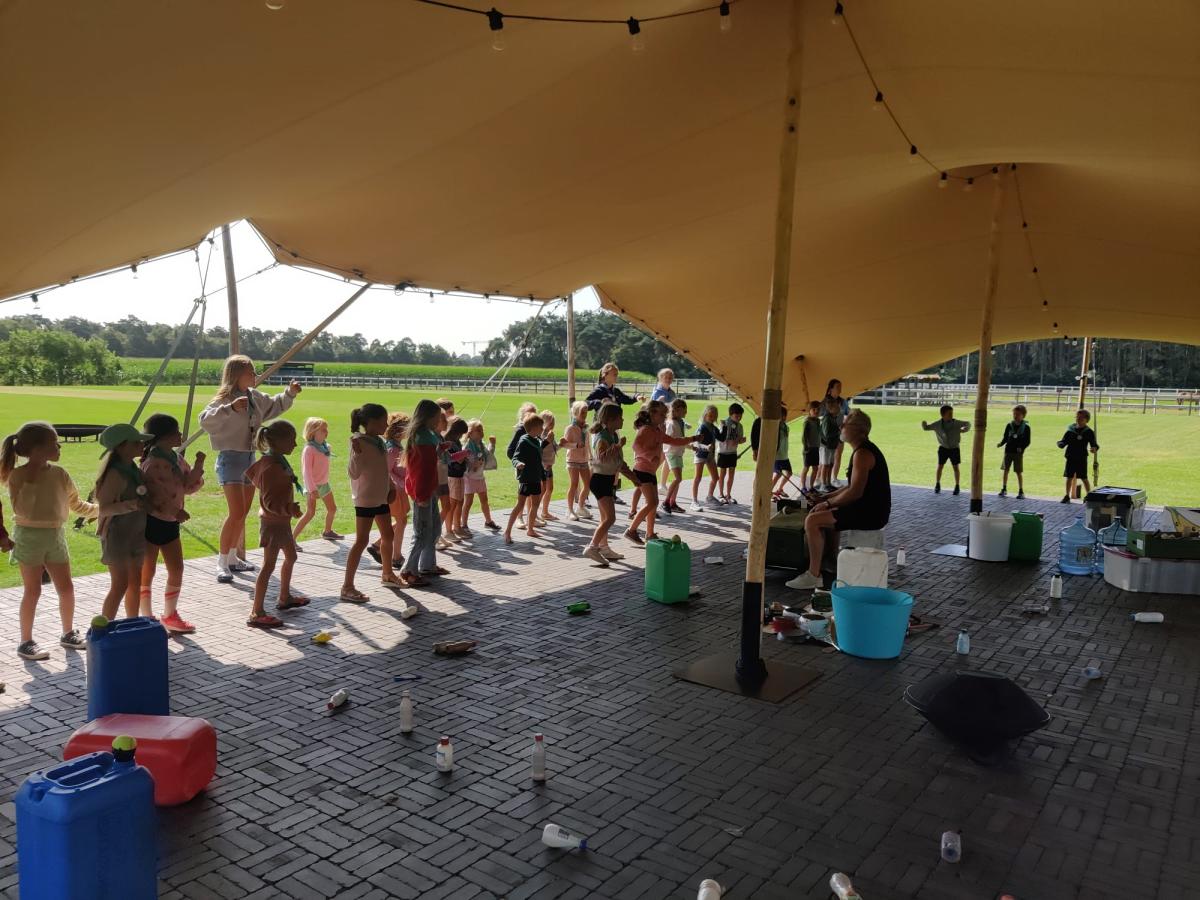 kinderen aan de slag tijdens een workshop eco-percussie.