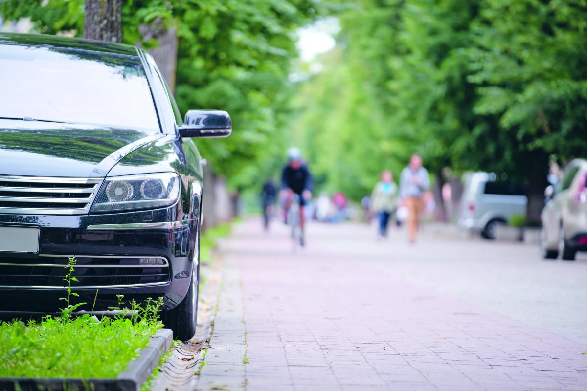 straatbeeld met wagen, fietsers en wandelaars