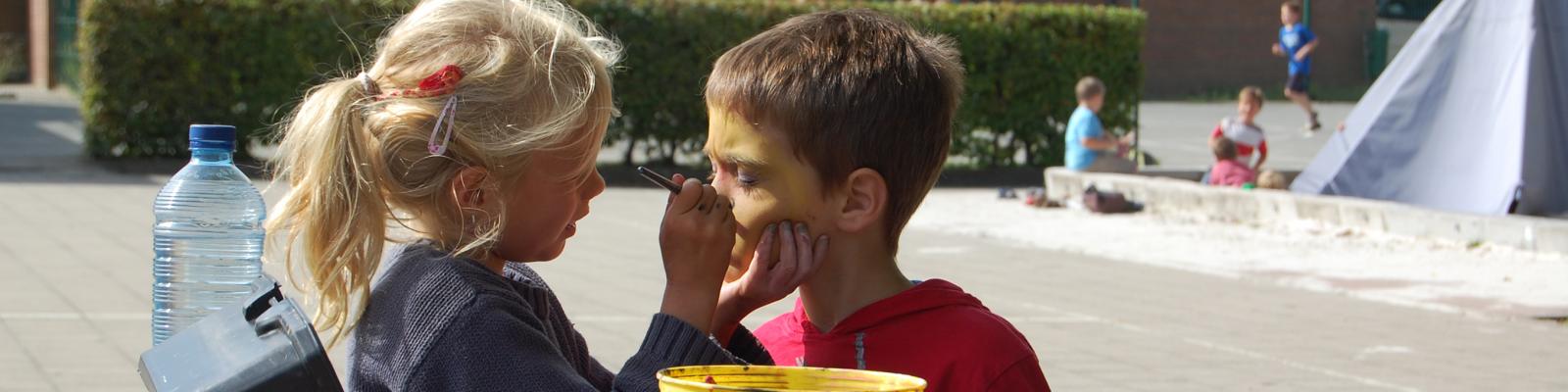 twee kinderen schminken elkaar