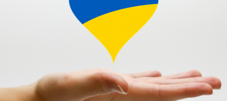 een hand draagt een hart in de kleuren van de Oekraïense vlag