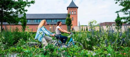twee fietsers fietsen langs de Trappistenabdij in Westmalle