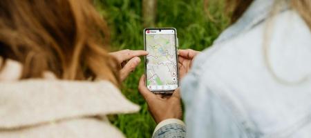 twee dames kijken op hun smartphone naar een online uitgestippelde wandelroute