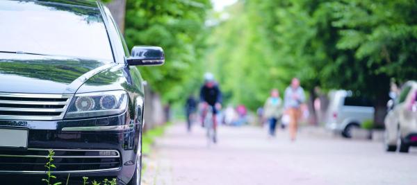 straatbeeld met wagen, fietsers en wandelaars