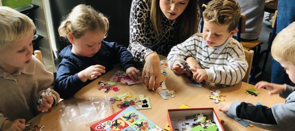 ouders en grootouders puzzelen met kleuters