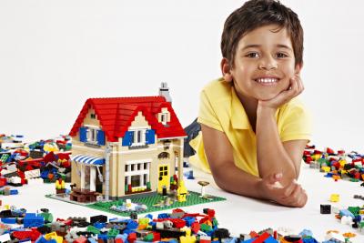 jongen naast huis gemaakt uit Lego