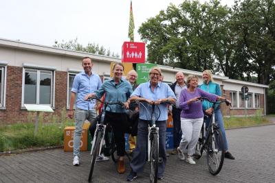 Olivier Rul, Liesbeth Verstreken, Jean Coen, Caroline Gennez, Marc De Cordt, Luc Kennis, Katrien Schryvers en Els Opdenbergh poseren met de fiets voor de SDG-blokken en één van de vlaggen