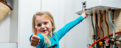 een meisje zet de temperatuur van de verwarmingsketel op 50 graden en steekt haar duim omhoog