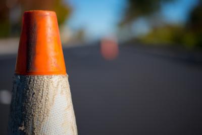 close-up van een verkeerskegel. Op de achtergrond zie je meer kegels staan.