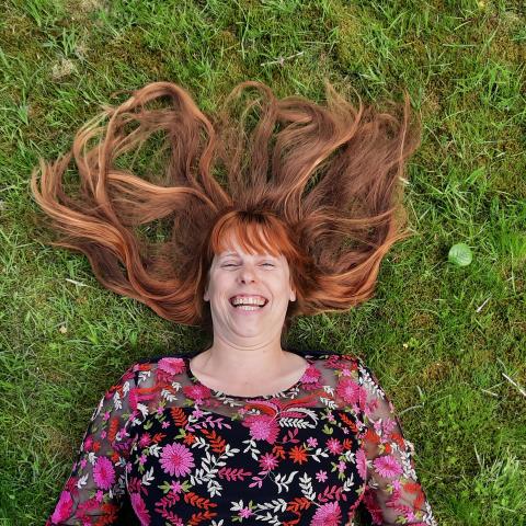 Lachende vrouw al liggend in het gras